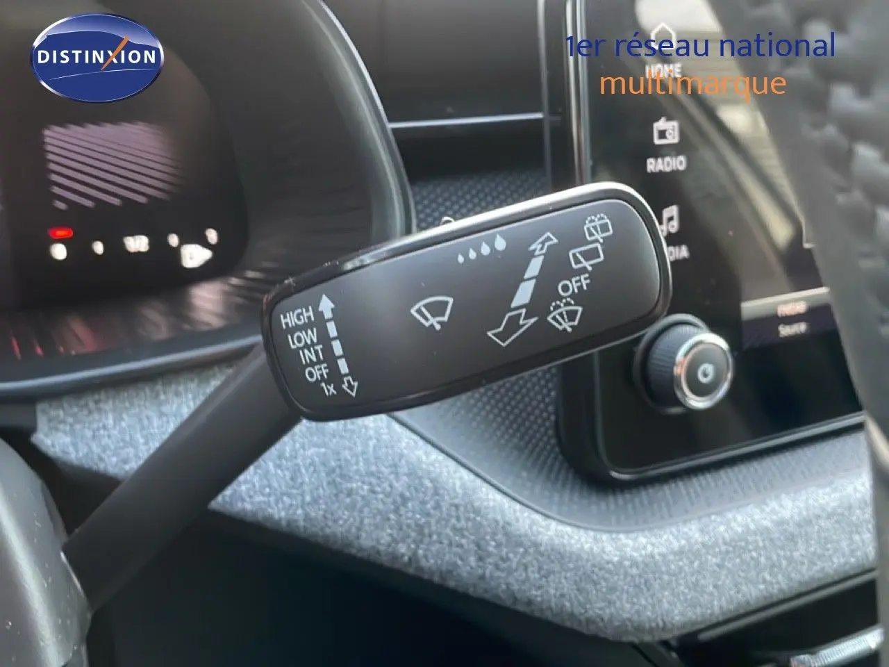 Gros plan sur la manette d'essuie-glace dans l'habitacle du Skoda Kamiq gris argent métal, avec tableau de bord en arrière-plan.