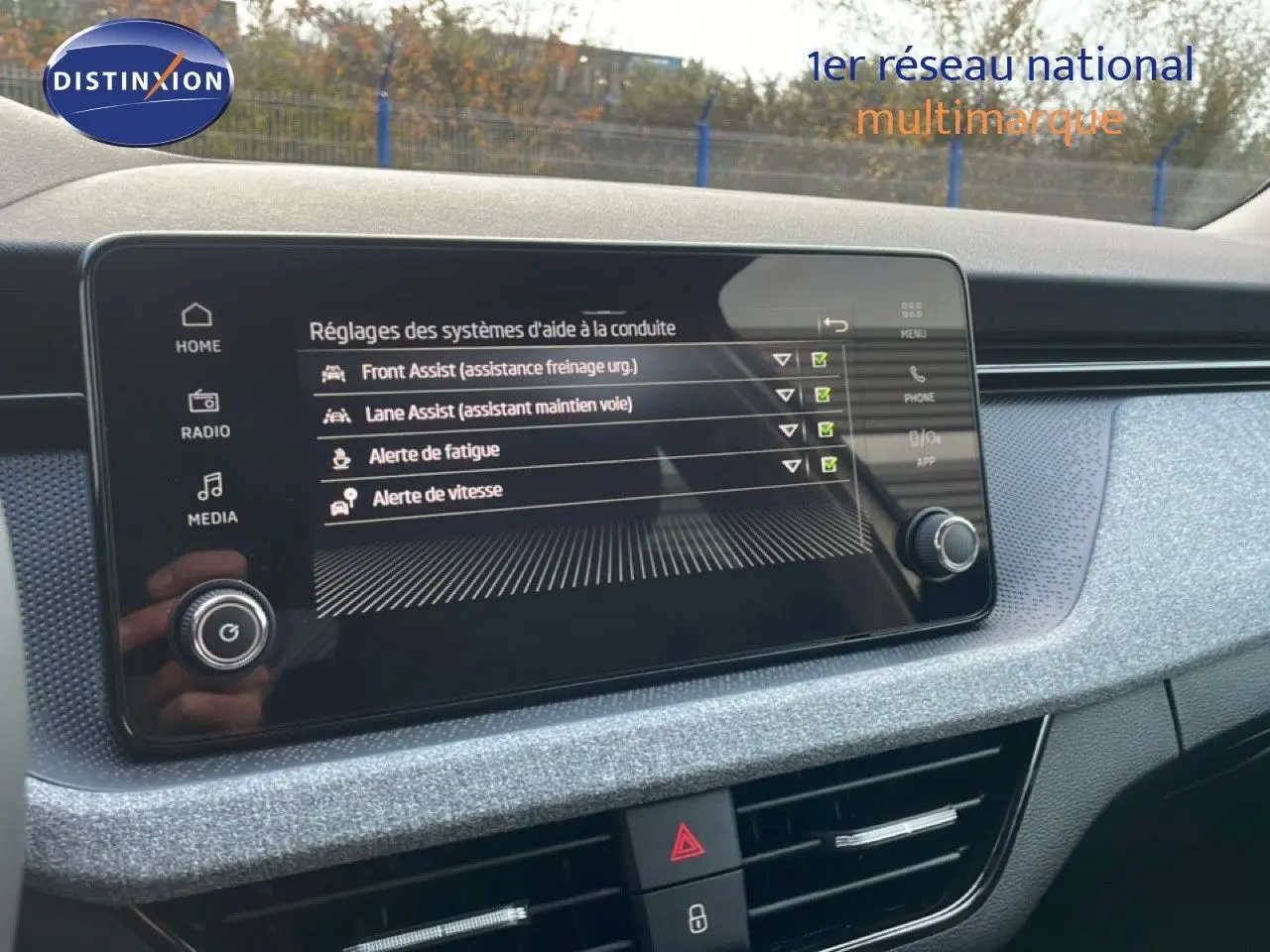 Écran tactile central affichant les réglages d’aide à la conduite dans un Skoda Kamiq, intérieur gris clair texturé.
