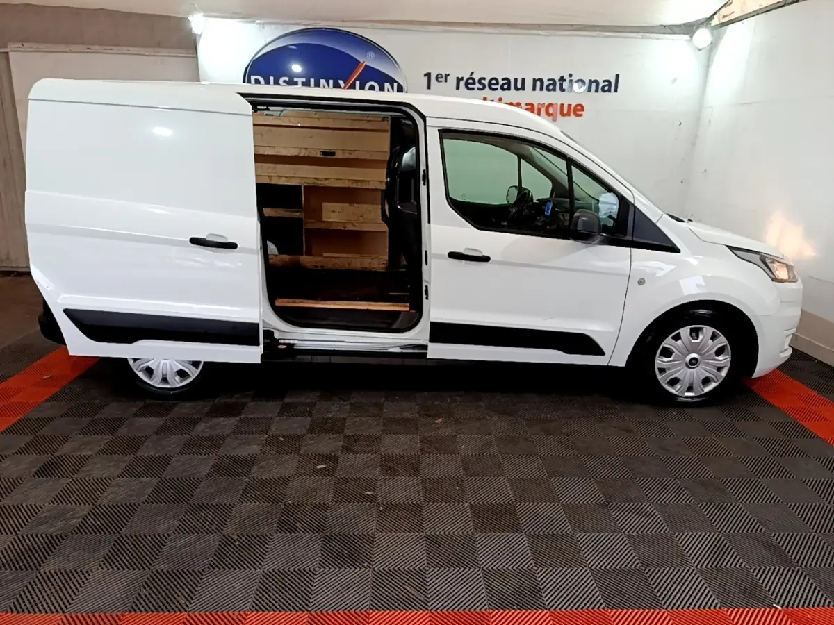 Vue de profil côté droit d’un Ford Transit Fourgon blanc 2022 avec porte latérale coulissante ouverte montrant l’intérieur boisé.