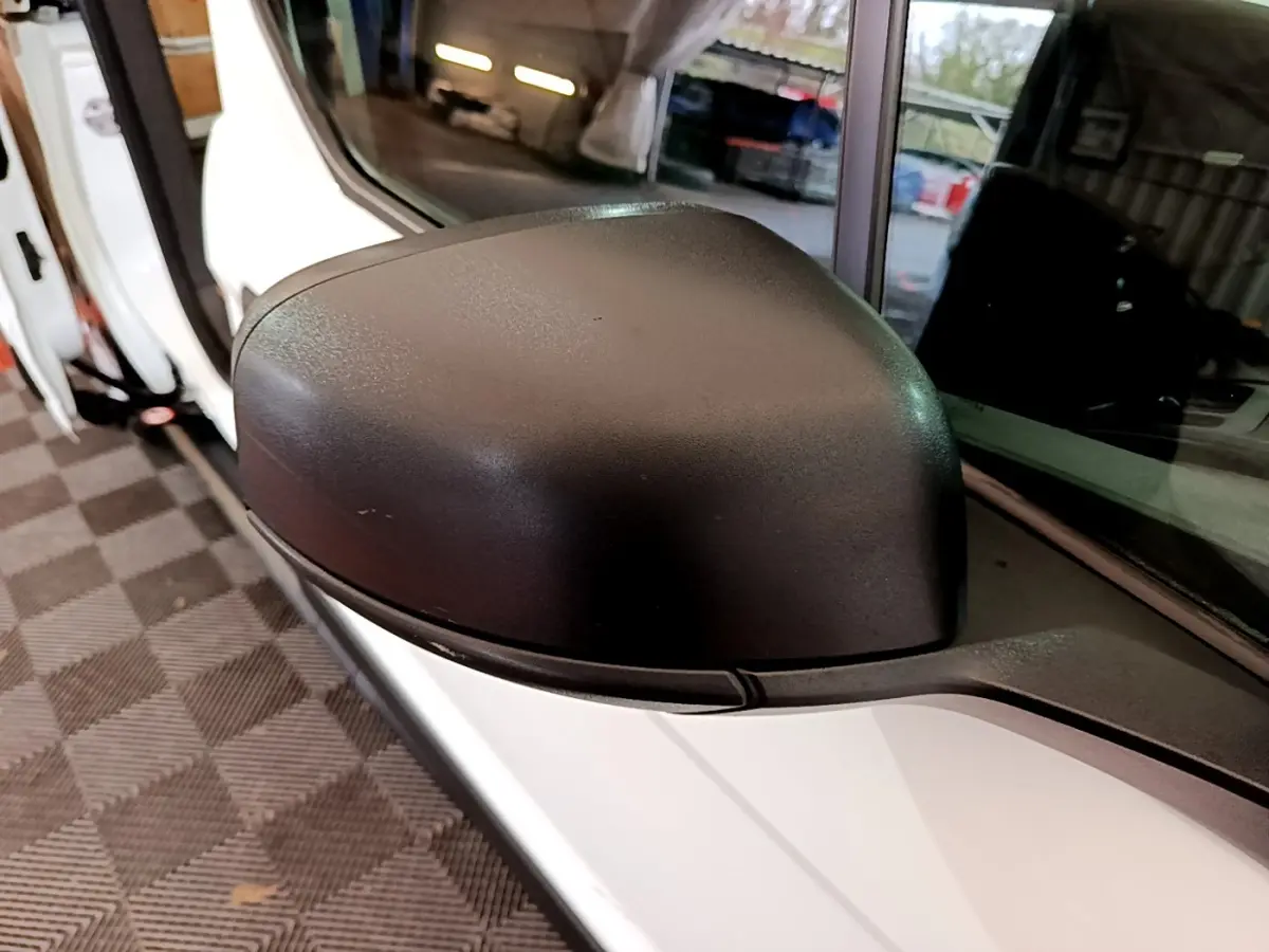 Gros plan sur le rétroviseur côté gauche du Ford Transit Fourgon blanc, avec porte ouverte en arrière-plan.