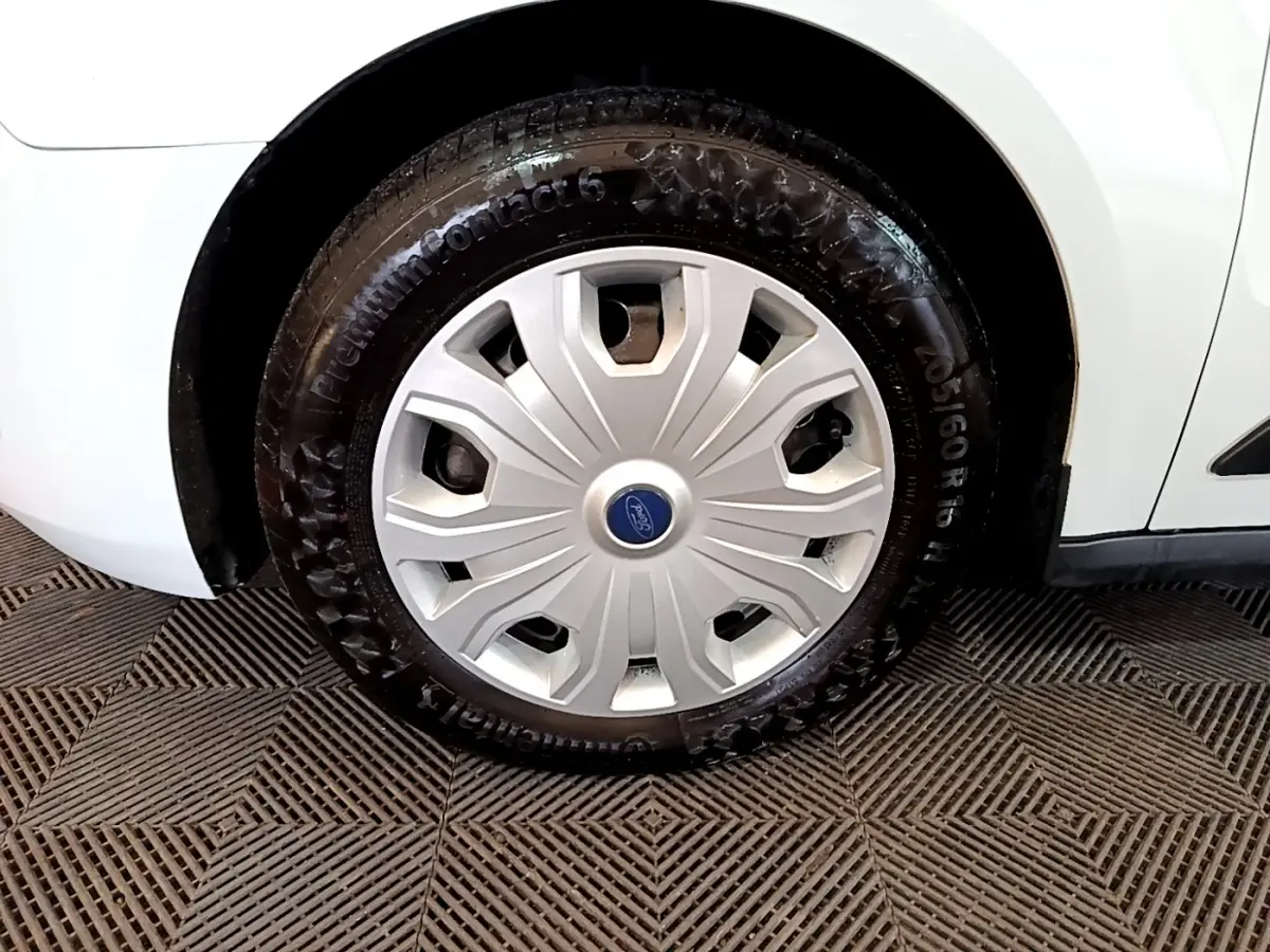 Gros plan sur la roue avant droite blanche du Ford Transit Fourgon 2022 avec enjoliveur argenté et logo Ford bleu.