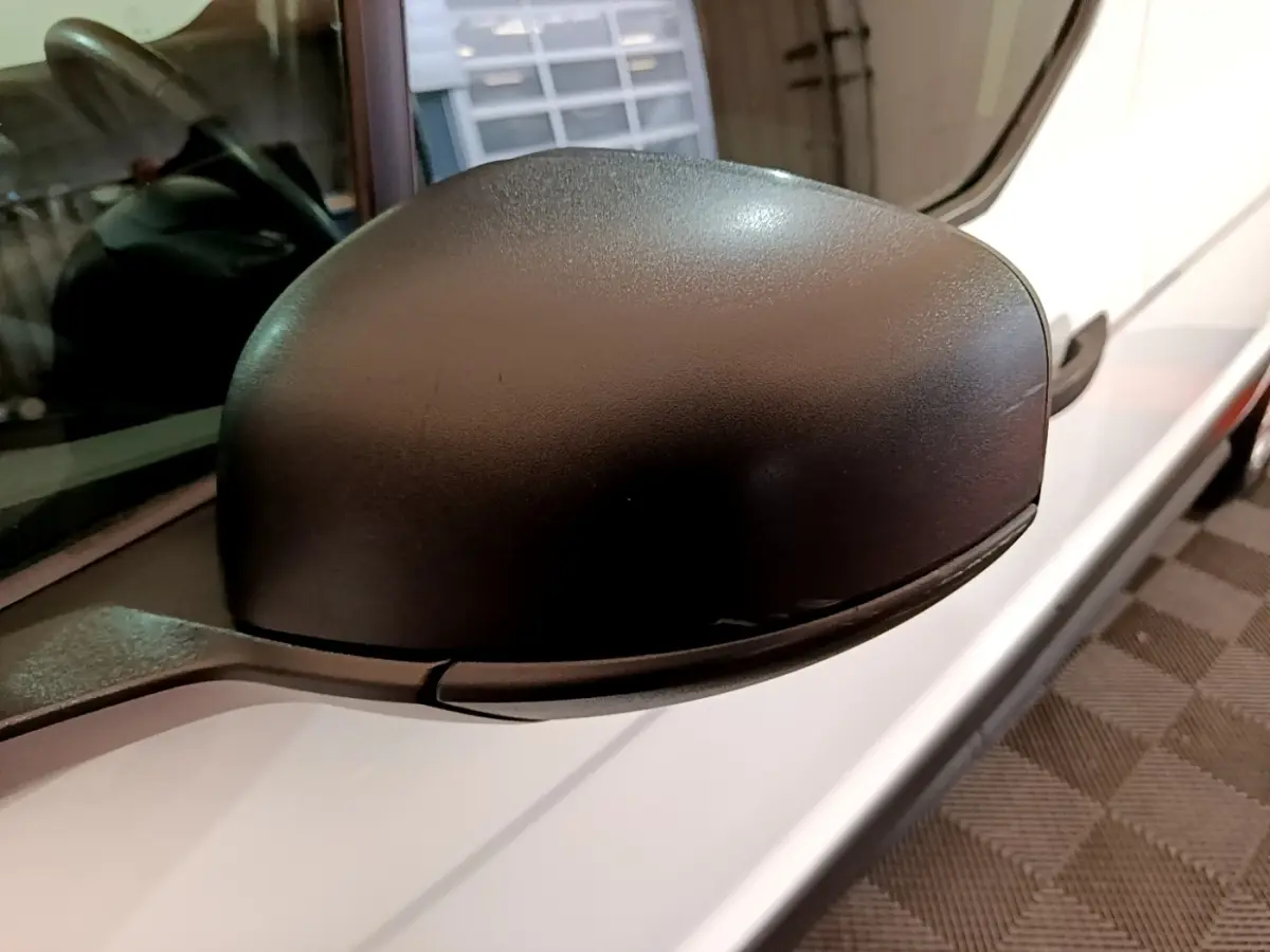 Rétroviseur noir côté gauche du Ford Transit Fourgon blanc, vue rapprochée sur la portière avant.