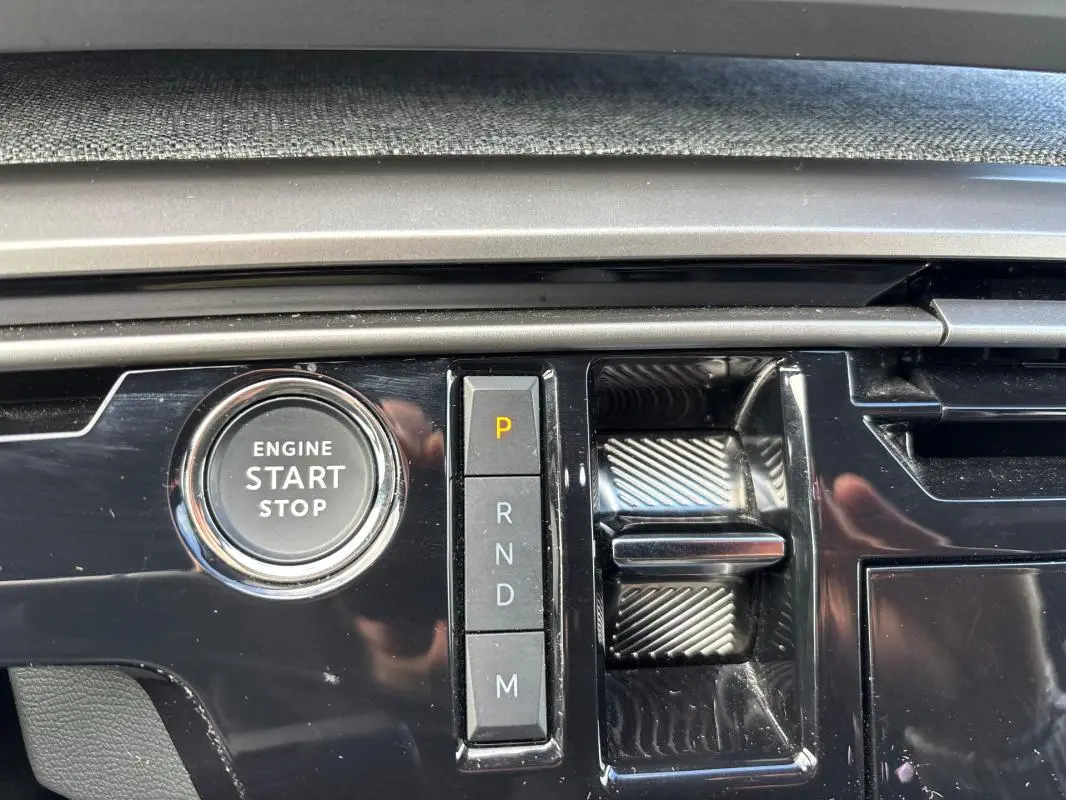 Gros plan sur la console centrale du Peugeot 3008 Hybrid gris, montrant le bouton start/stop et la sélection de vitesses automatique.