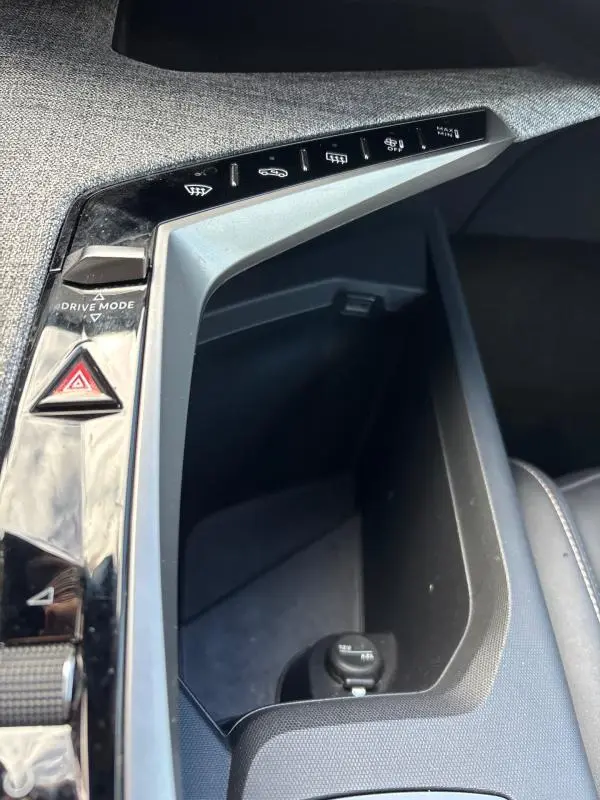 Gros plan sur la console centrale du Peugeot 3008 Hybrid 145 e-DCS6 Allure 2025, avec commandes et rangement intérieur.