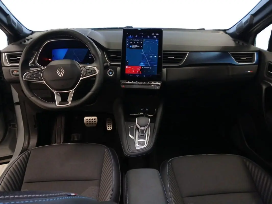 Vue intérieure frontale du tableau de bord noir du Renault Symbioz E-Tech avec écran tactile vertical et volant multifonction.