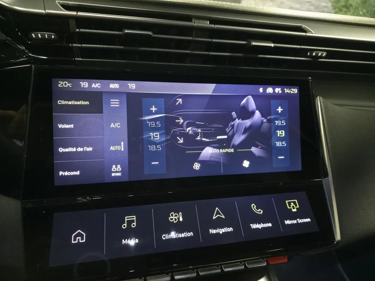 Écran tactile central de la Peugeot 408 gris, affichant les réglages de climatisation et de confort intérieur.