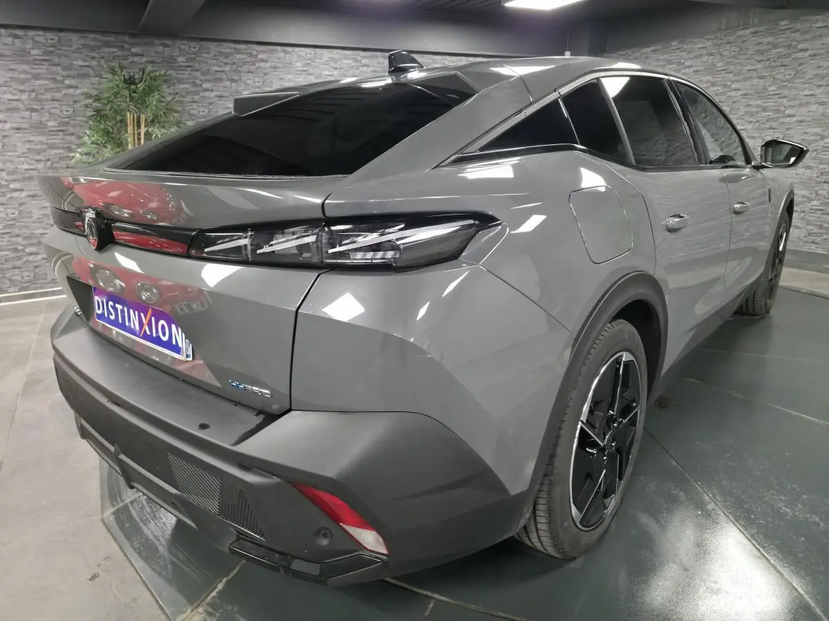 Vue 3/4 arrière droit d'une Peugeot 408 gris métallisé avec feux arrière LED griffés et jantes alliage 19 pouces.