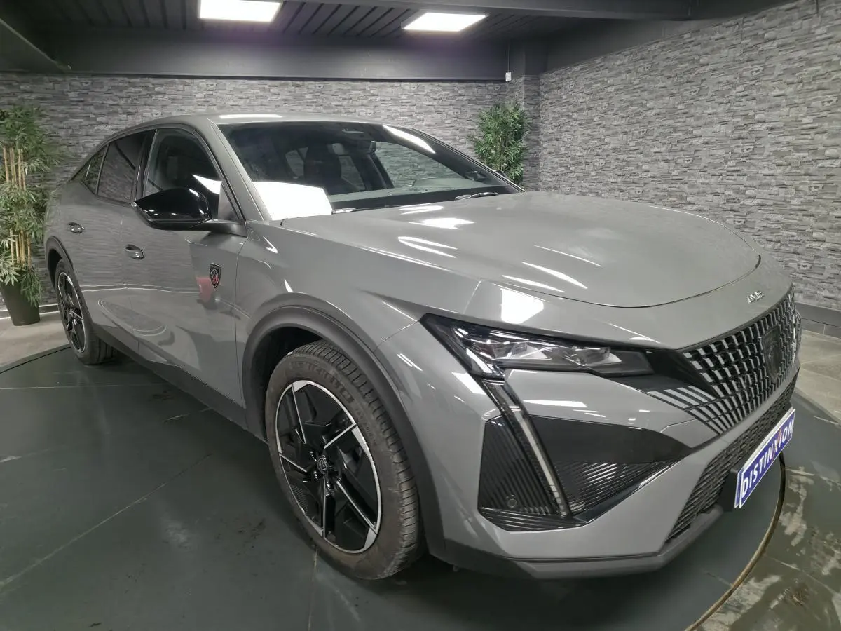 Peugeot 408 gris Selenium vue 3/4 avant droit, calandre noire distinctive et jantes alliage 19 pouces diamantées.