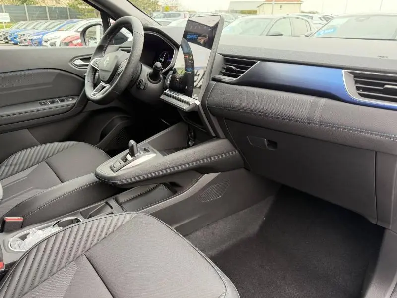Vue intérieure côté conducteur du Renault Captur 2026 hybride, avec tableau de bord moderne et écran tactile vertical.