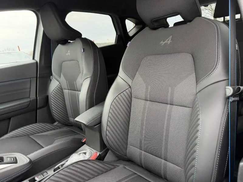 Vue rapprochée des sièges avant noirs avec surpiqûres bleues et logo Alpine brodé sur le Renault Captur 1.8 E-Tech hybride 2026.