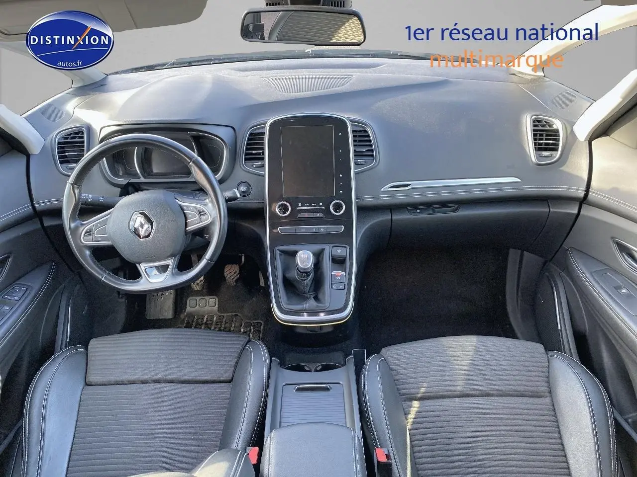 Vue intérieure avant du Renault Grand Scenic IV 2019, tableau de bord avec écran tactile vertical et volant cuir noir.