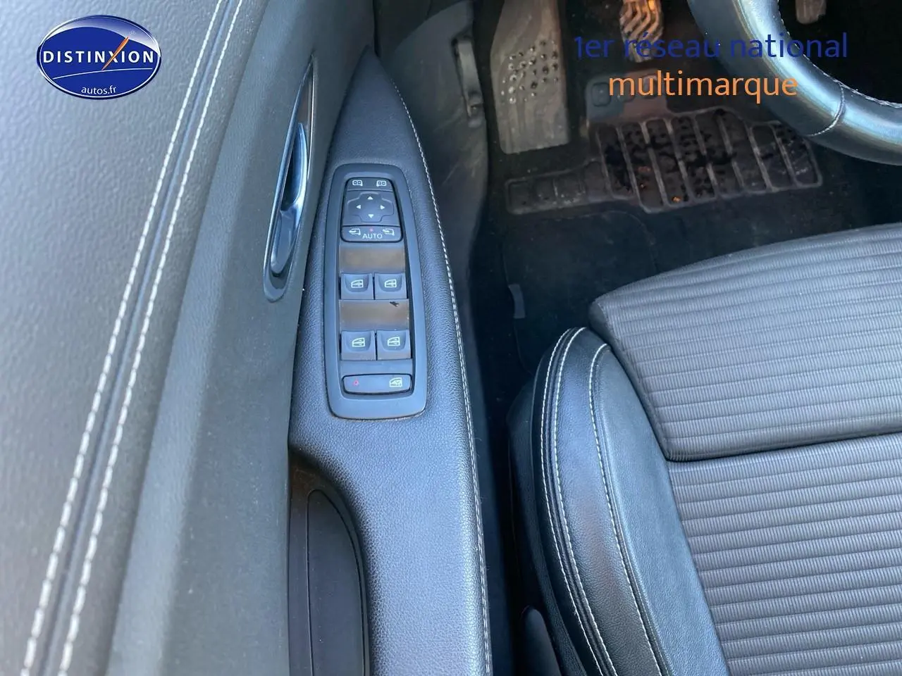 Vue rapprochée de la porte avant gauche d’un Renault Grand Scenic IV 2019, avec commandes de vitres et sellerie noire.