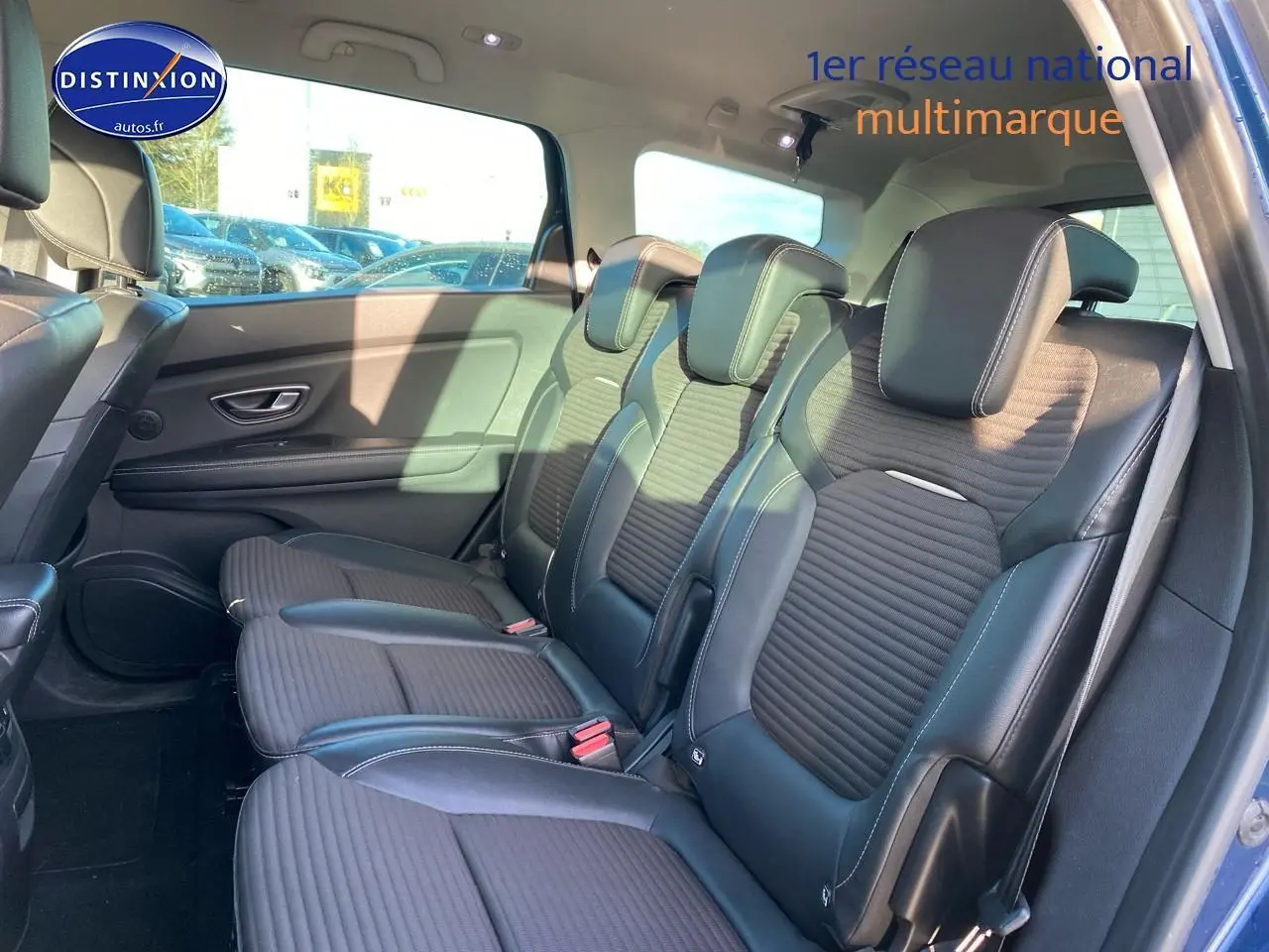 Vue latérale des sièges arrière en similicuir noir du Renault Grand Scenic IV bleu, avec appuie-têtes et ceintures visibles.
