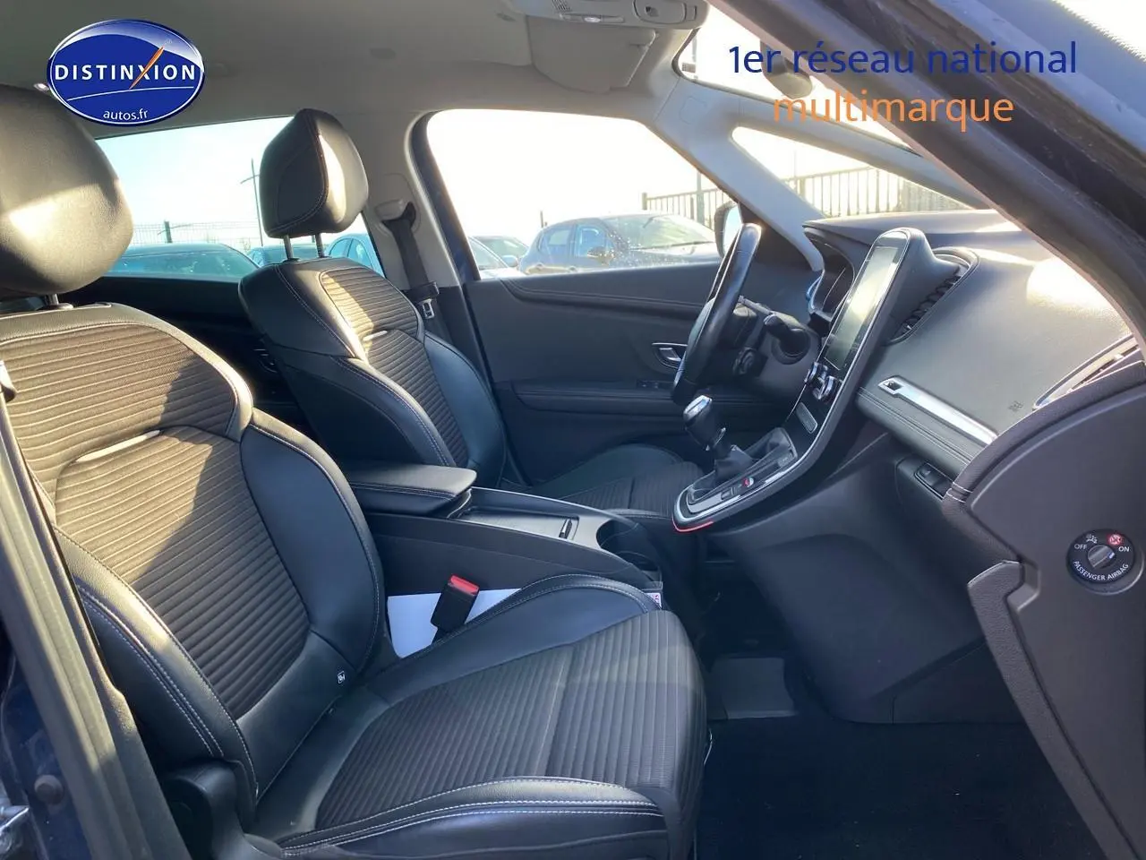Vue intérieure côté conducteur du Renault Grand Scenic IV bleu 2019, avec sièges en similicuir noir et écran tactile vertical.