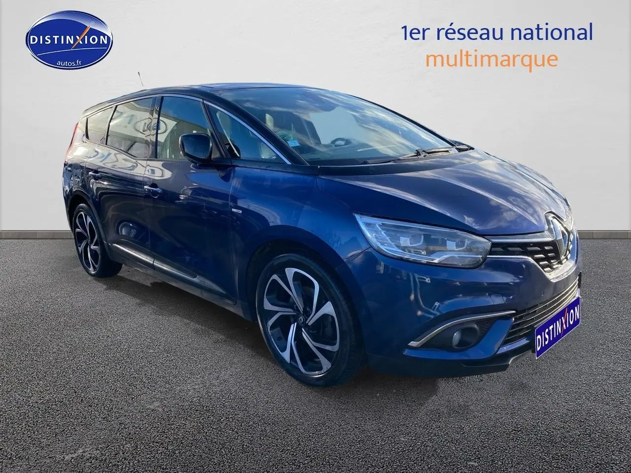 Renault Grand Scénic IV bleu en 3/4 avant droit, avec jantes alliage 20 pouces et phares LED distinctifs.