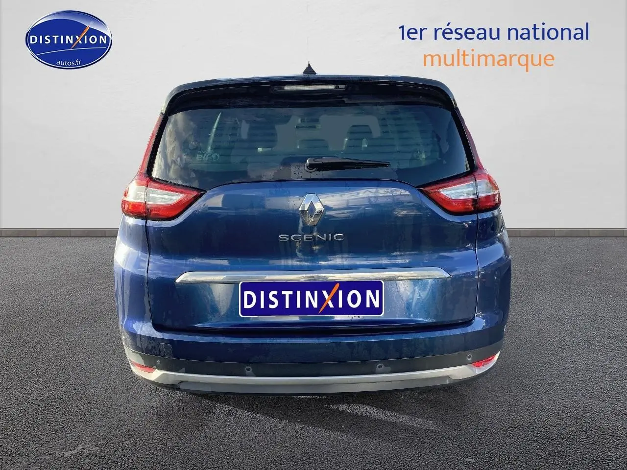 Vue arrière d’un Renault Grand Scenic IV bleu avec feux arrière distinctifs et logo au centre du hayon.