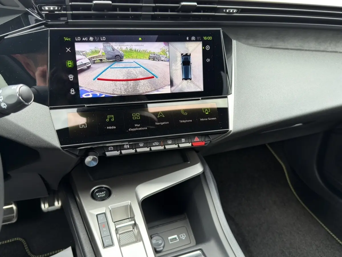 Vue intérieure du tableau de bord de la Peugeot 308 2026 avec écran tactile affichant la caméra de recul et console centrale.