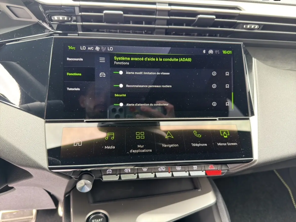 Gros plan sur l’écran tactile central du tableau de bord d’une Peugeot 308 gris clair, affichant l’aide à la conduite.