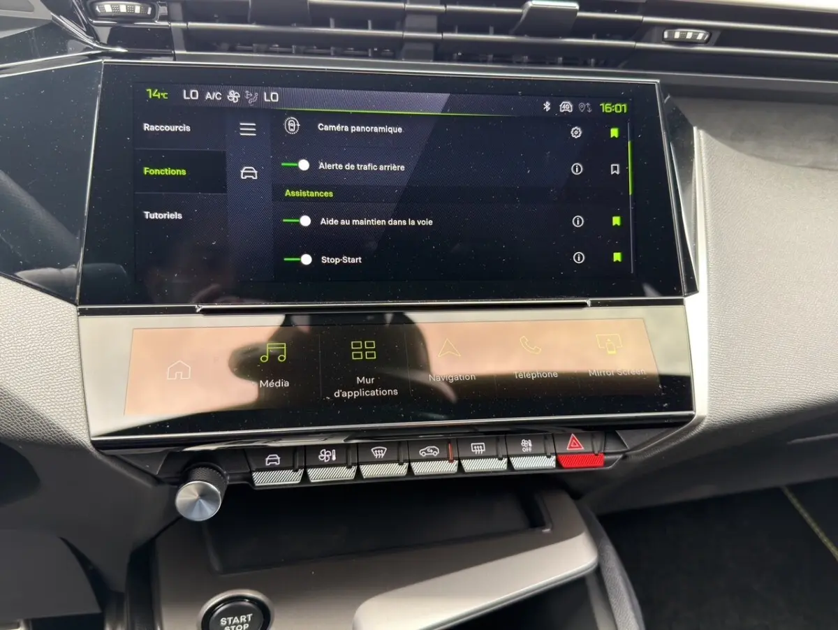 Vue rapprochée de l’écran tactile central et des commandes du tableau de bord intérieur d’une Peugeot 308 gris clair.