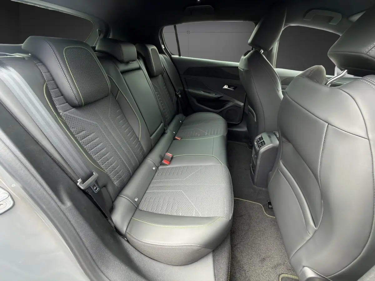 Vue intérieure arrière côté gauche de la Peugeot 308 gris clair, sièges en cuir et tissu avec surpiqûres contrastées.