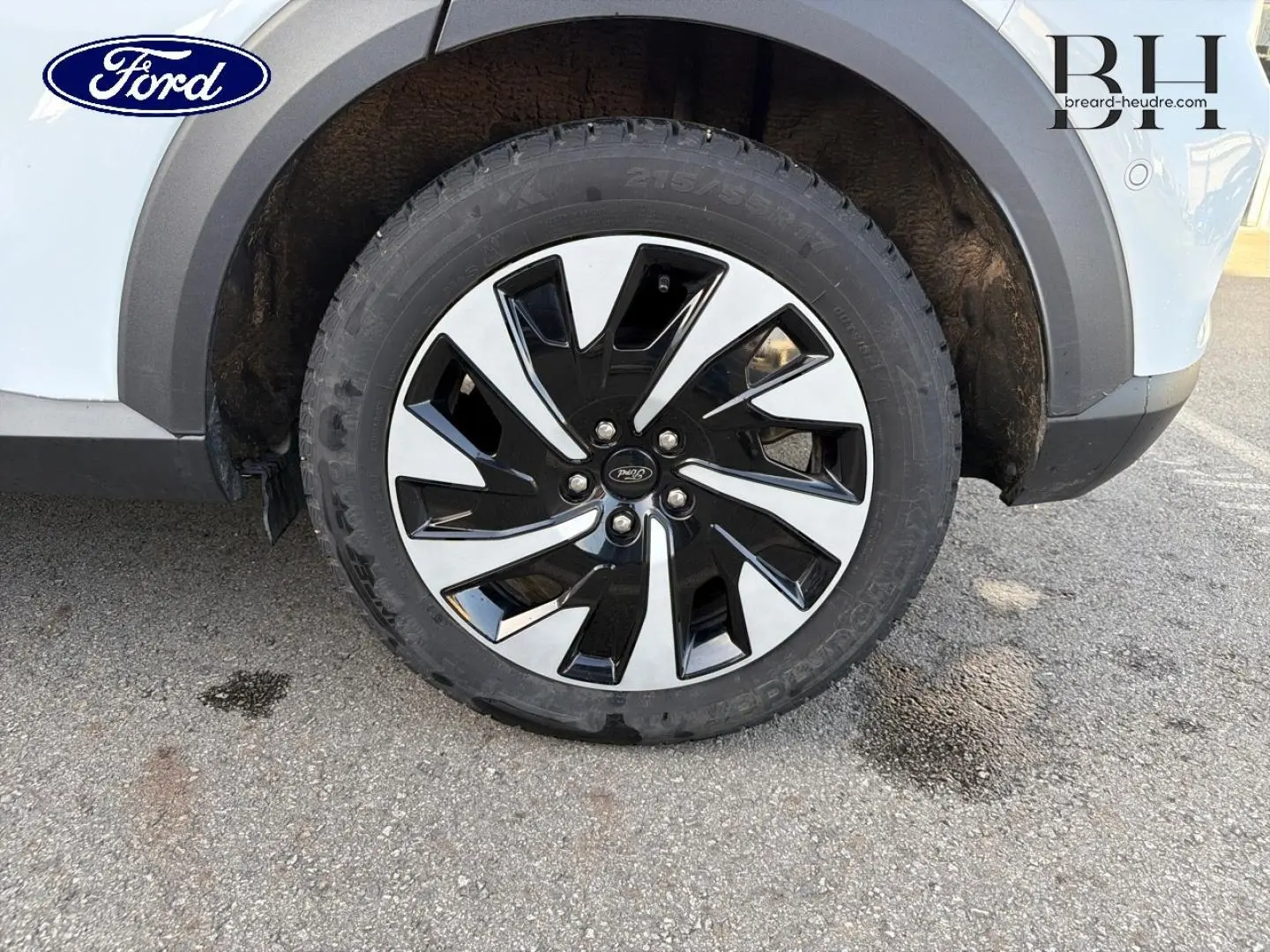Gros plan sur la roue avant droite du Ford Puma blanc Glacier, mettant en valeur la jante bicolore noire et argent.