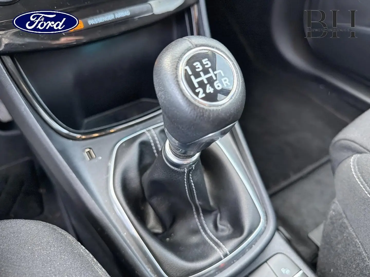 Gros plan sur le levier de vitesses manuel noir avec surpiqûres blanches dans l’habitacle d’une Ford Puma 2023.