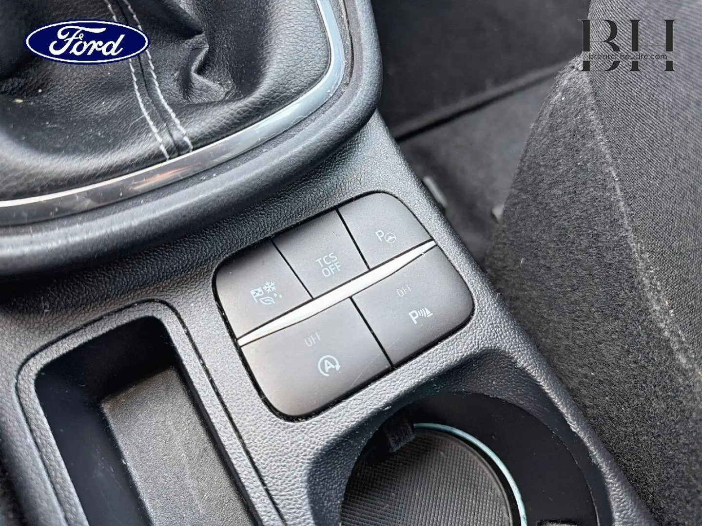 Gros plan sur la console centrale noire du Ford Puma 2023, montrant les boutons de contrôle près du levier de vitesse.