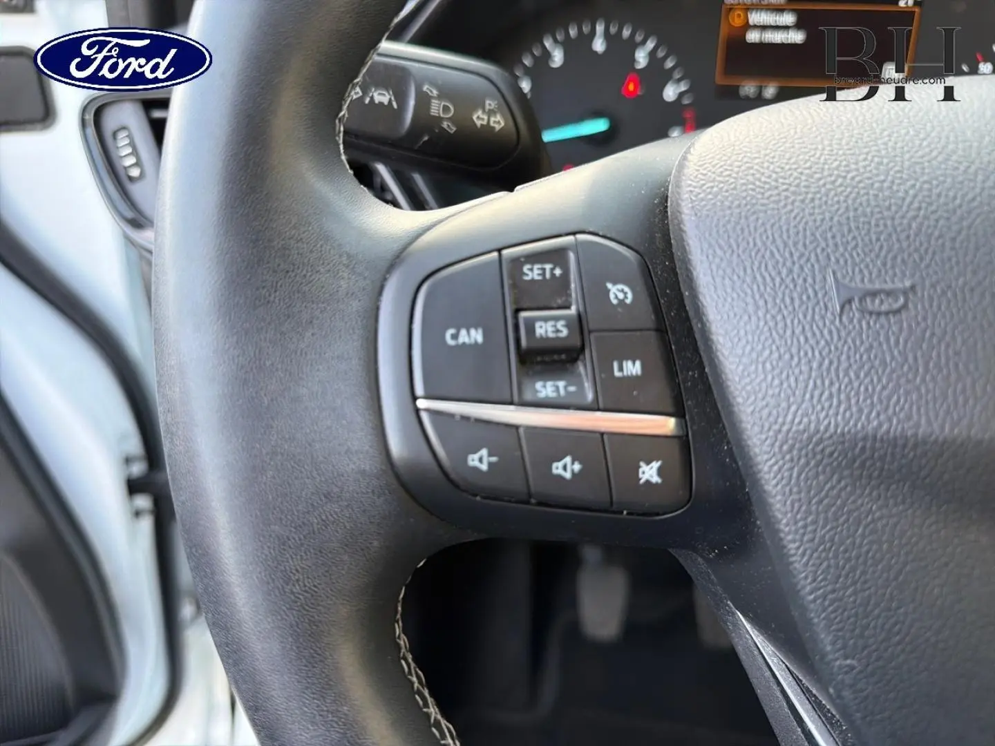 Gros plan sur le volant multifonction noir du Ford Puma 2023, avec commandes de régulateur et audio visibles.
