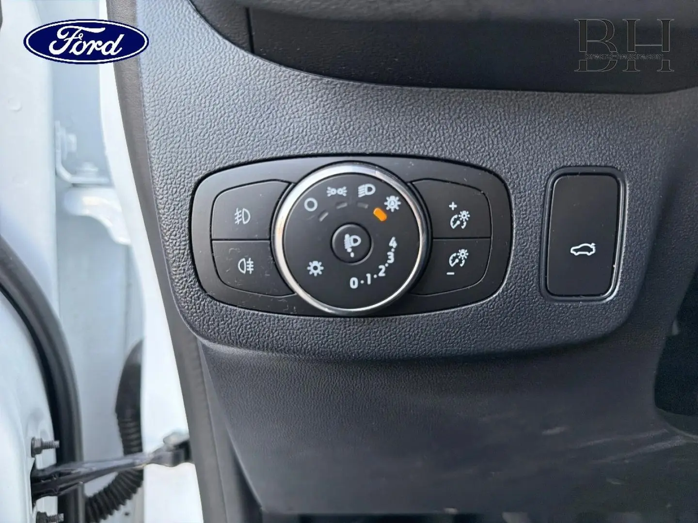 Détail du panneau de commandes d’éclairage et ouverture du hayon sur Ford Puma blanc Glacier 2023.
