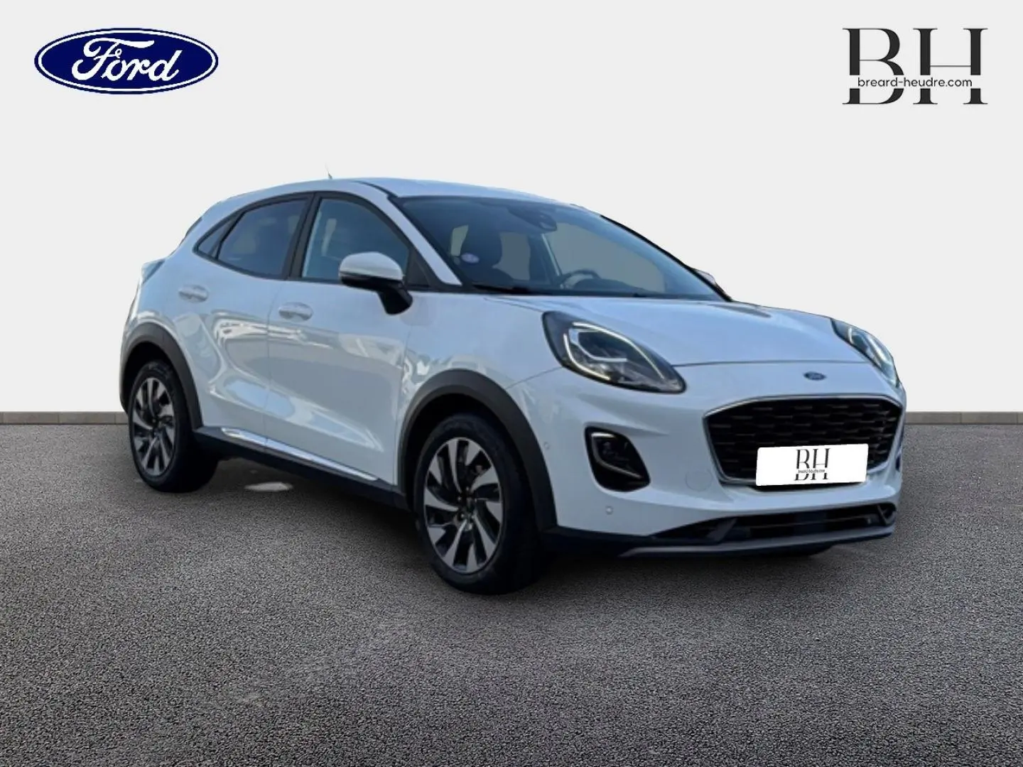 Ford Puma blanc glacier vu en 3/4 avant droit, avec calandre noire et jantes alliage bicolores.