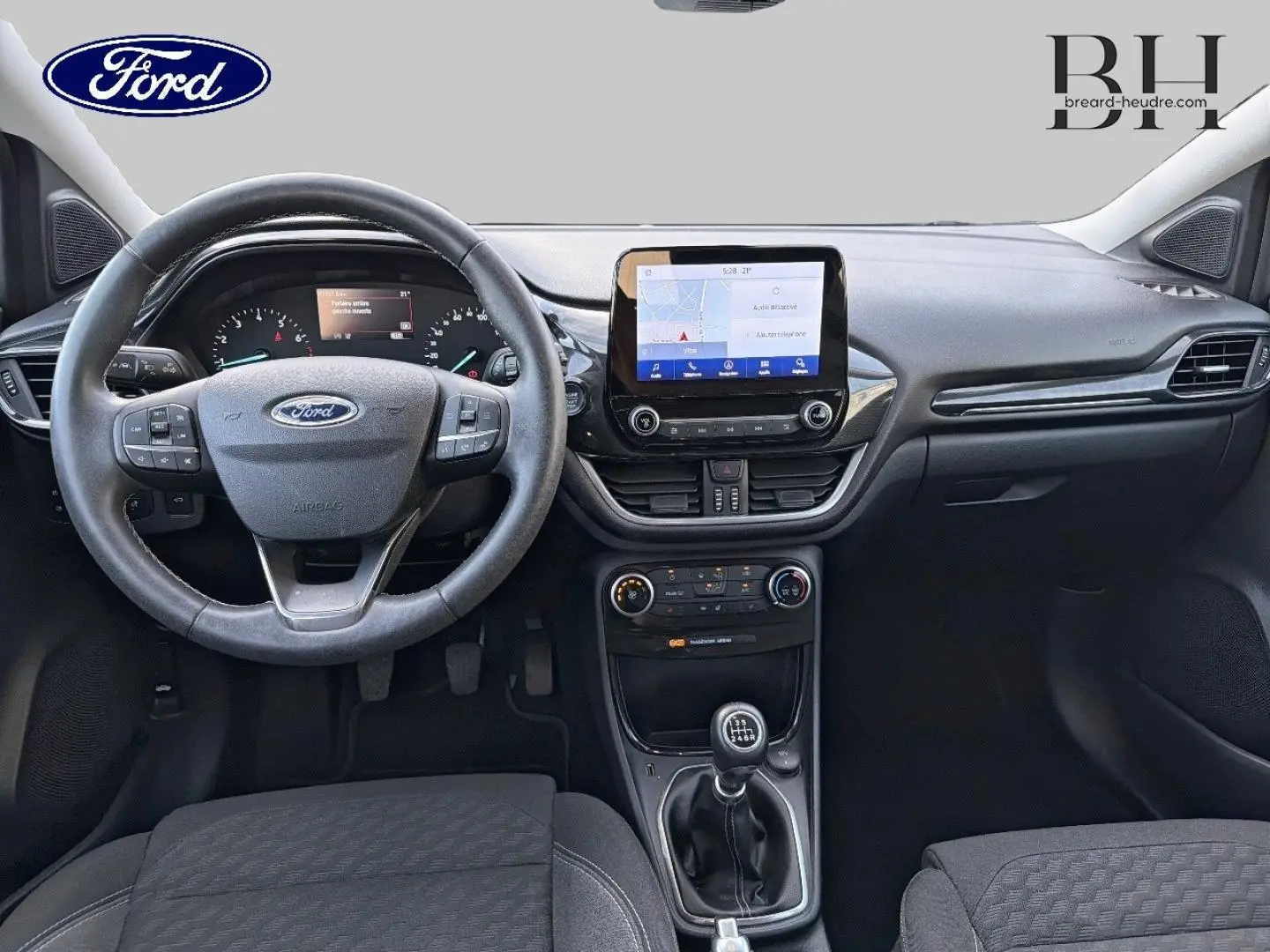 Vue intérieure frontale du tableau de bord et volant noir du Ford Puma 2023 avec écran tactile et boîte manuelle.