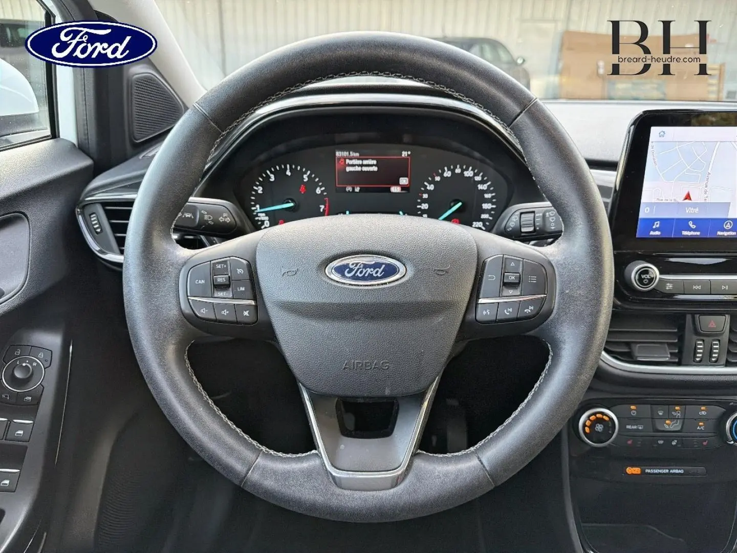Vue centrée sur le volant noir multifonction du Ford Puma 2023 avec tableau de bord et écran tactile visible.