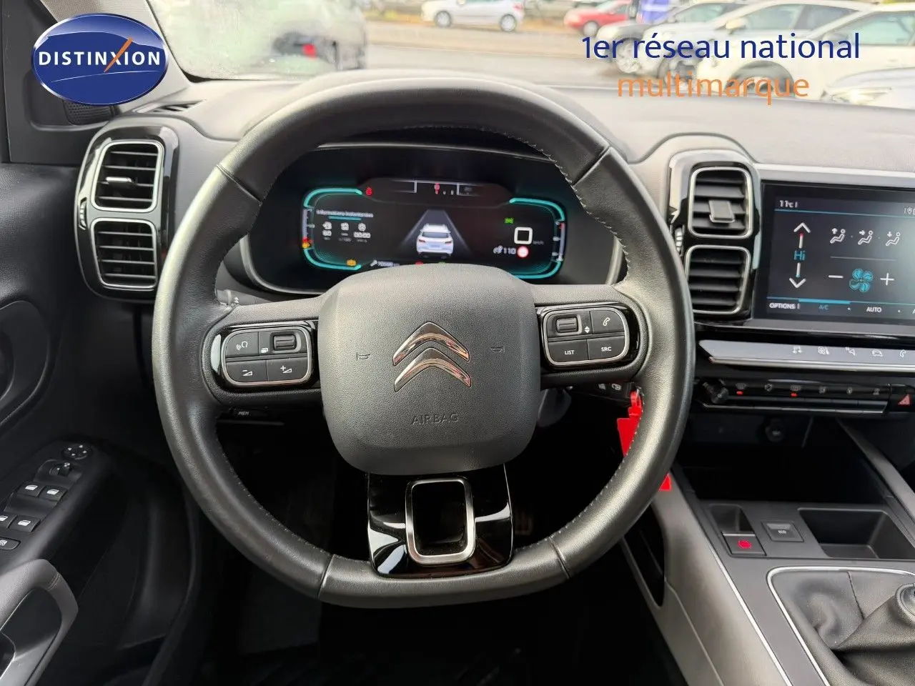 Vue intérieure centrée sur le volant en cuir noir du Citroën C5 Aircross, avec tableau de bord numérique et écran tactile.