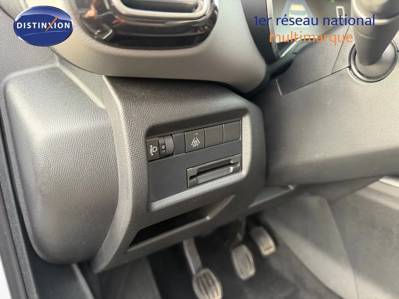 Détail de la console côté conducteur du Citroën C5 Aircross blanc nacré, montrant les commandes d’éclairage et les pédales.