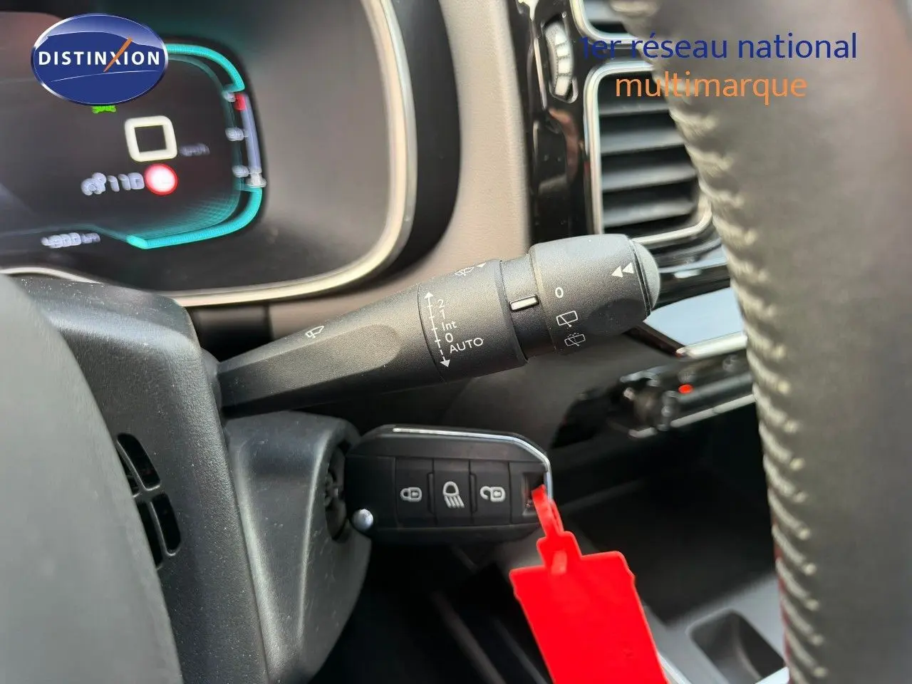 Gros plan sur la commande d’essuie-glace et clé avec porte-clés rouge dans l’habitacle d’un Citroën C5 Aircross blanc nacré.