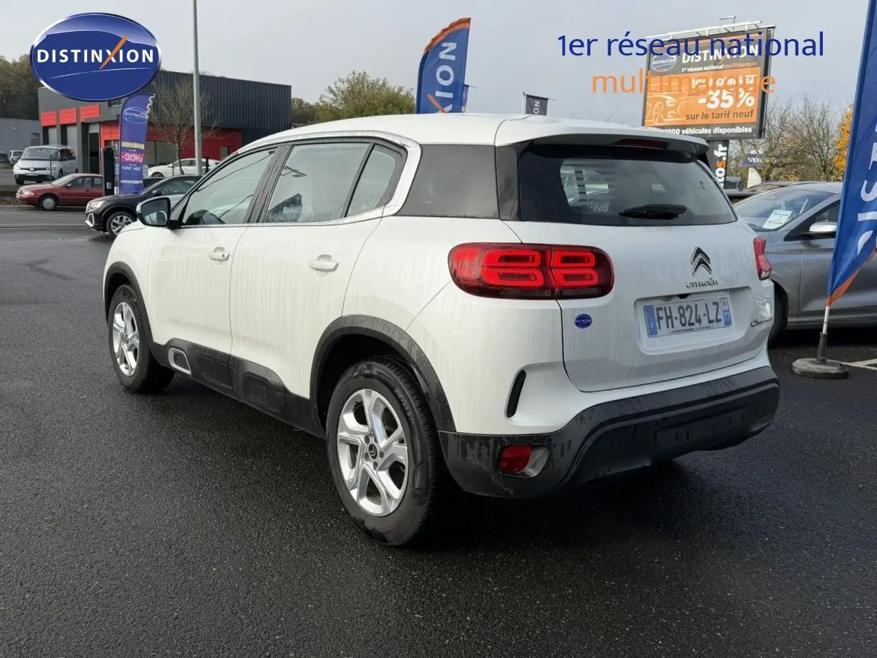 Vue 3/4 arrière droite d’un Citroën C5 Aircross blanc nacré avec feux arrière LED et jantes alliage argentées.