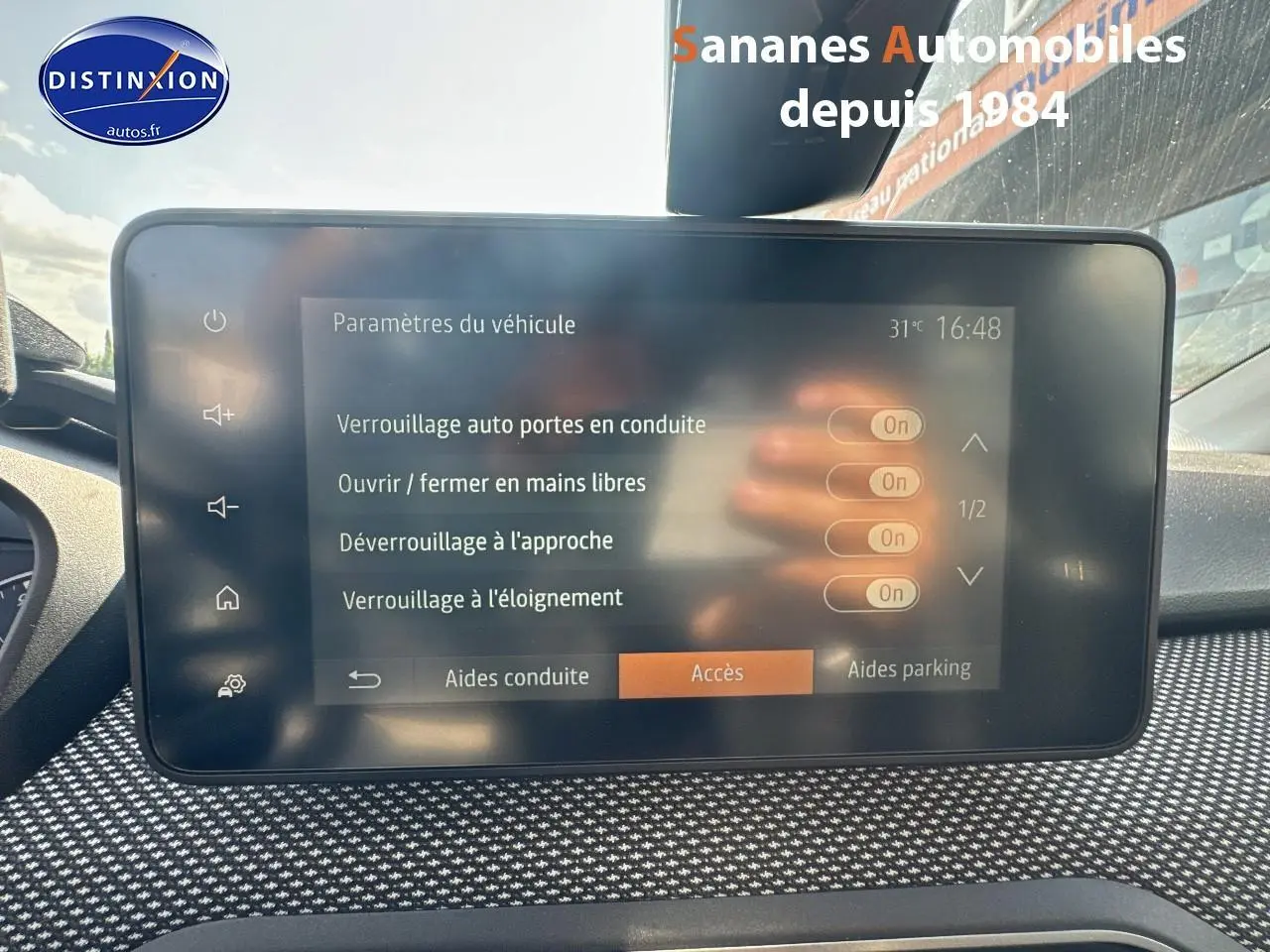 Écran tactile central du tableau de bord du Dacia Jogger blanc, affichant les paramètres d'accès au véhicule.