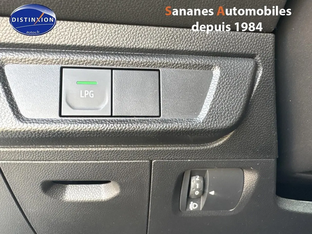 Gros plan sur le bouton LPG de la console intérieure noire du Dacia Jogger blanc, version 2023 bicarburation.