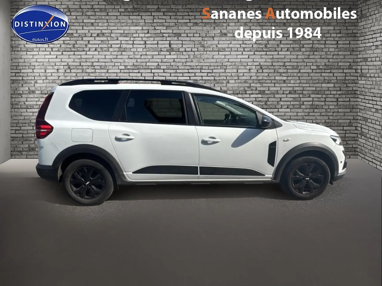 Vue latérale droite d'un Dacia Jogger blanc glacier avec jantes noires et vitres arrière surteintées.