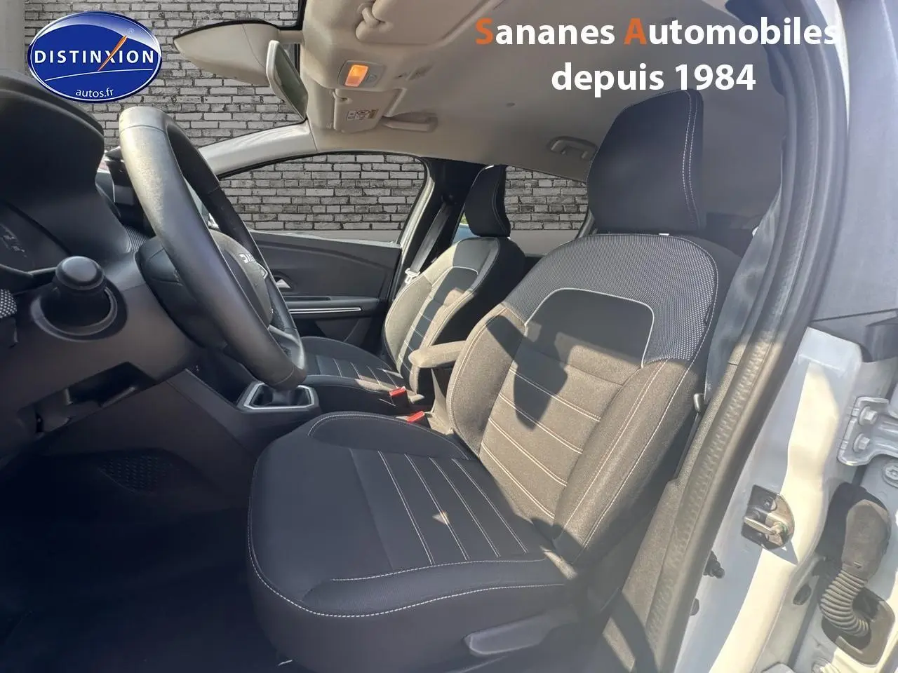Intérieur de la Dacia Jogger 2023, vue côté gauche avant, sièges tissu noirs et volant réglable.