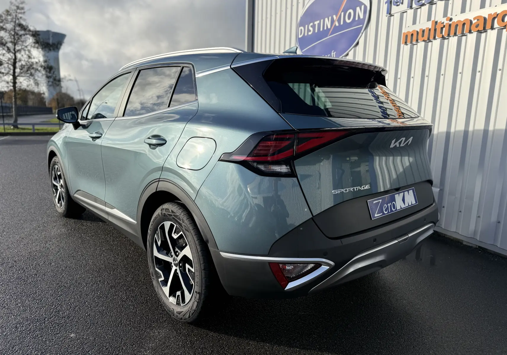 Vue 3/4 arrière du KIA SPORTAGE gris Sirius 2025 avec feux LED et jantes bi-ton noires.