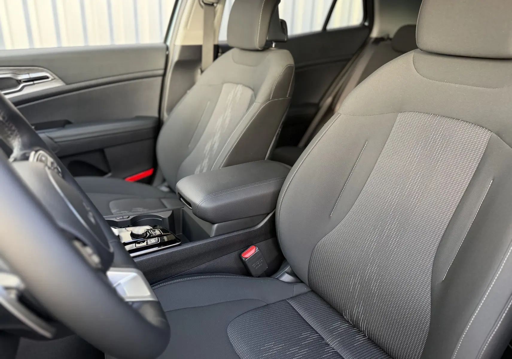 Coffre ouvert d'un KIA SPORTAGE gris Sirius 2025, vue arrière montrant l'espace de chargement vide.