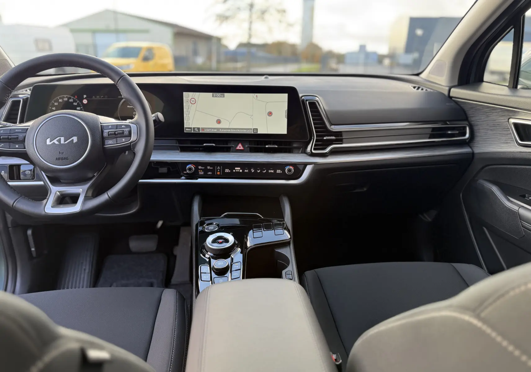 Écran central du Kia Sportage 2025 montrant la caméra de recul avec lignes de guidage et détection d'obstacles.