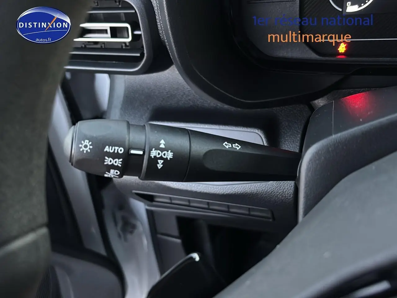 Gros plan sur la commande des feux et clignotants côté gauche du tableau de bord d'un Citroën Berlingo Fourgon blanc 2025.