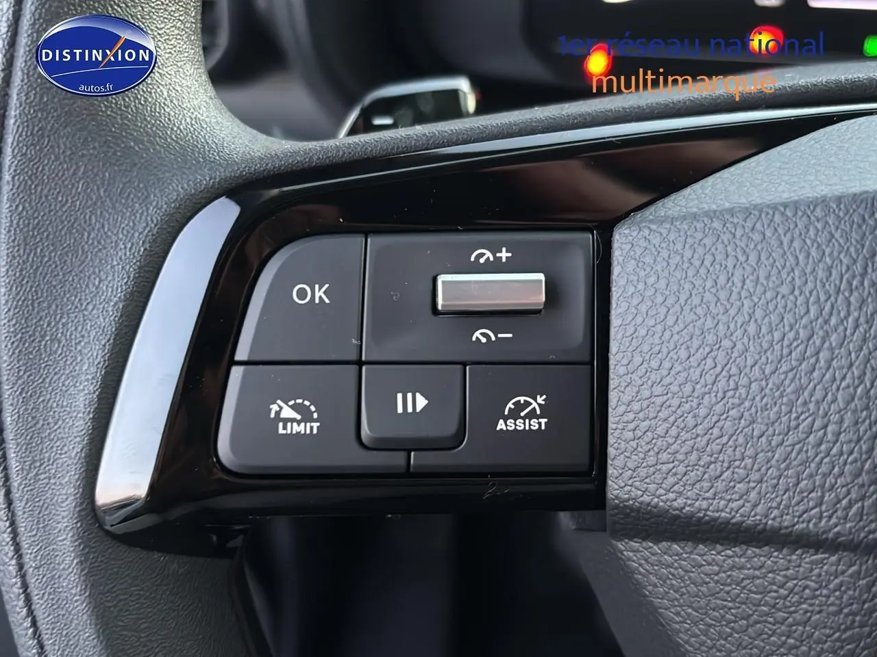 Gros plan sur les commandes de régulateur de vitesse au volant du Citroën Berlingo Fourgon blanc, intérieur noir.