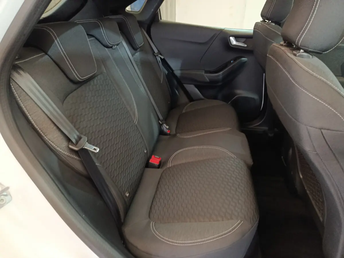 Vue intérieure côté gauche des sièges arrière noirs avec surpiqûres blanches du Ford Puma blanc 2022.