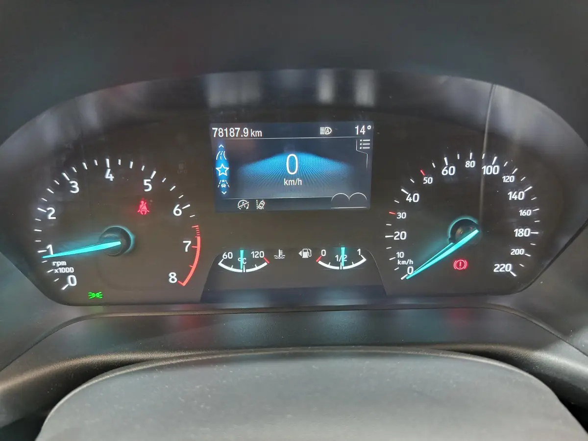 Vue rapprochée du tableau de bord du Ford Puma blanc 2022, affichage numérique et compte-tours éclairés en bleu.