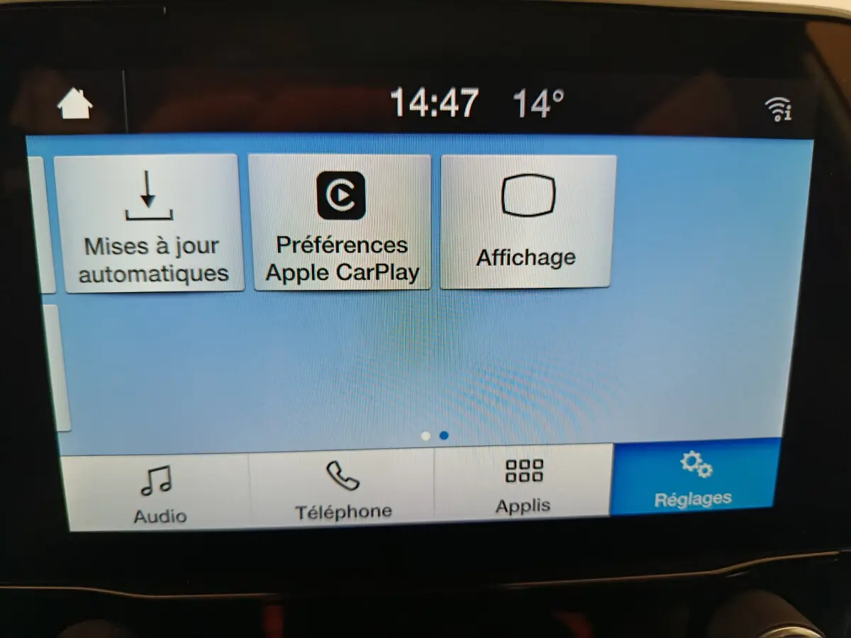 Écran tactile central du Ford Puma blanc 2022 affichant les réglages Apple CarPlay et mises à jour automatiques.