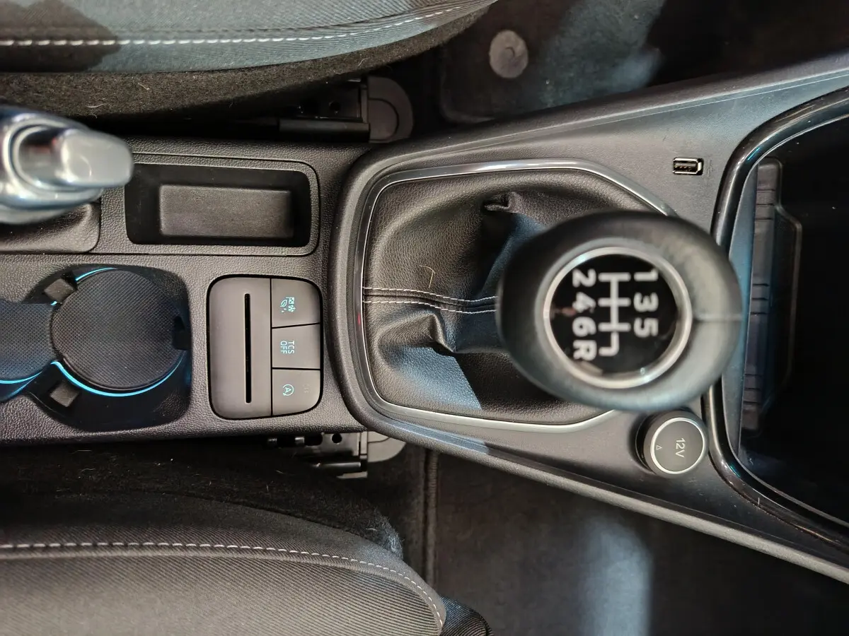 Gros plan sur la console centrale noire du Ford Puma 2022, mettant en valeur le levier de vitesses manuel et les commandes adjacentes.