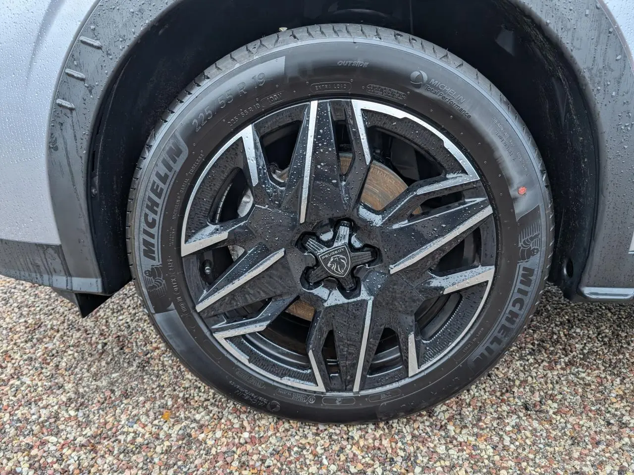 Gros plan sur la jante alliage 19'' diamantée noire et brillante du côté gauche d’un Peugeot 5008 gris 2025.